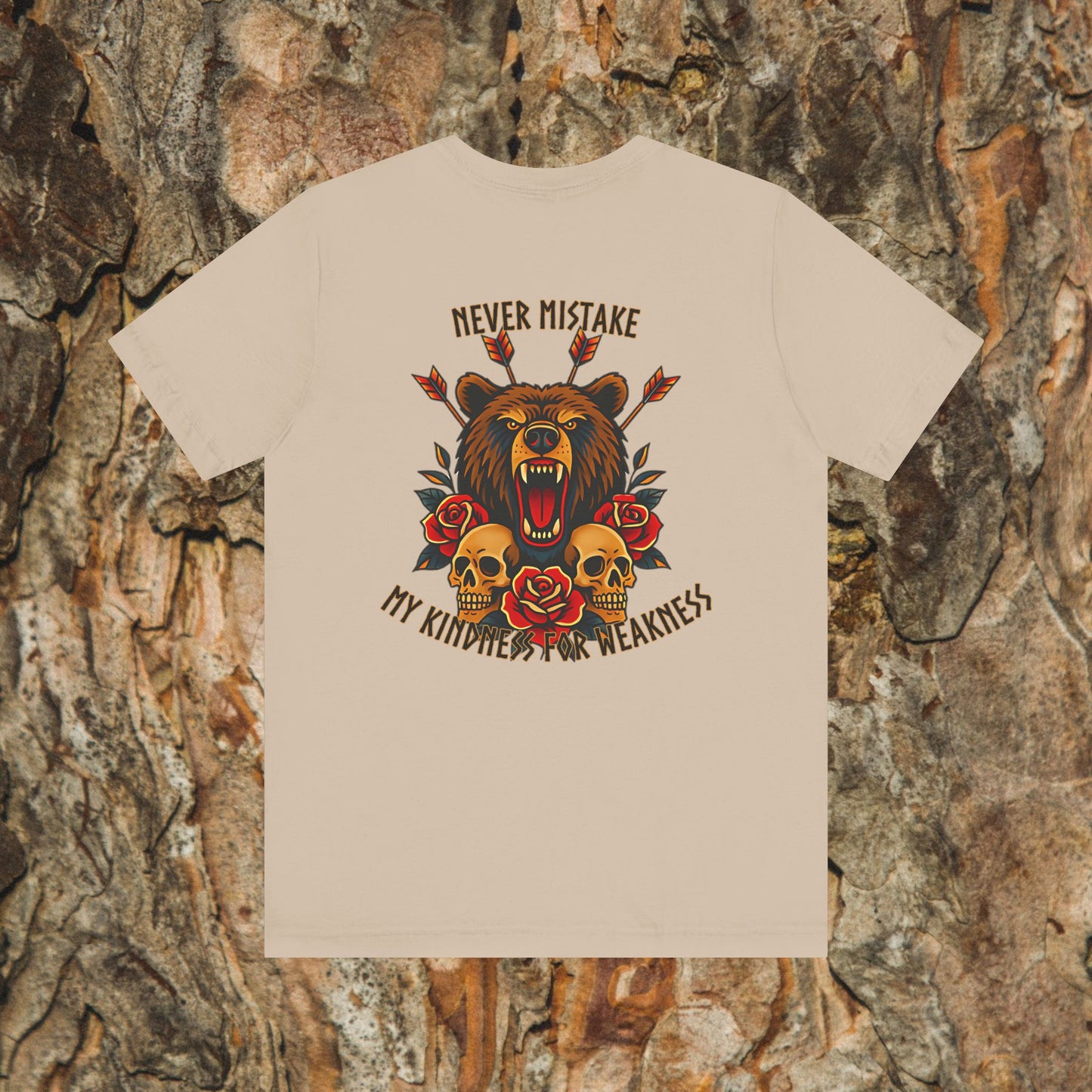 Printify’s Never Mistake My Kindness For Weakness Tee is a beige unisex Airlume cotton shirt with a roaring bear, skulls, roses, arrows, and bold text. Displayed on textured bark background.