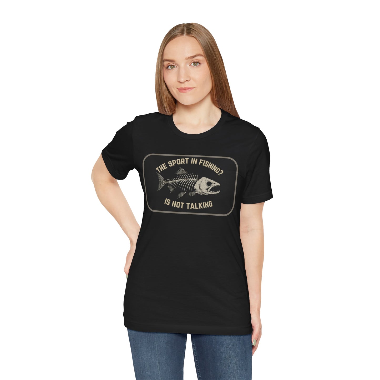 A woman with long straight hair models the Printify The Sport in Fishing?” Tee, a unisex shirt with a distressed fish skeleton graphic and the phrase “The sport in fishing? Is not talking,” standing against a white background.