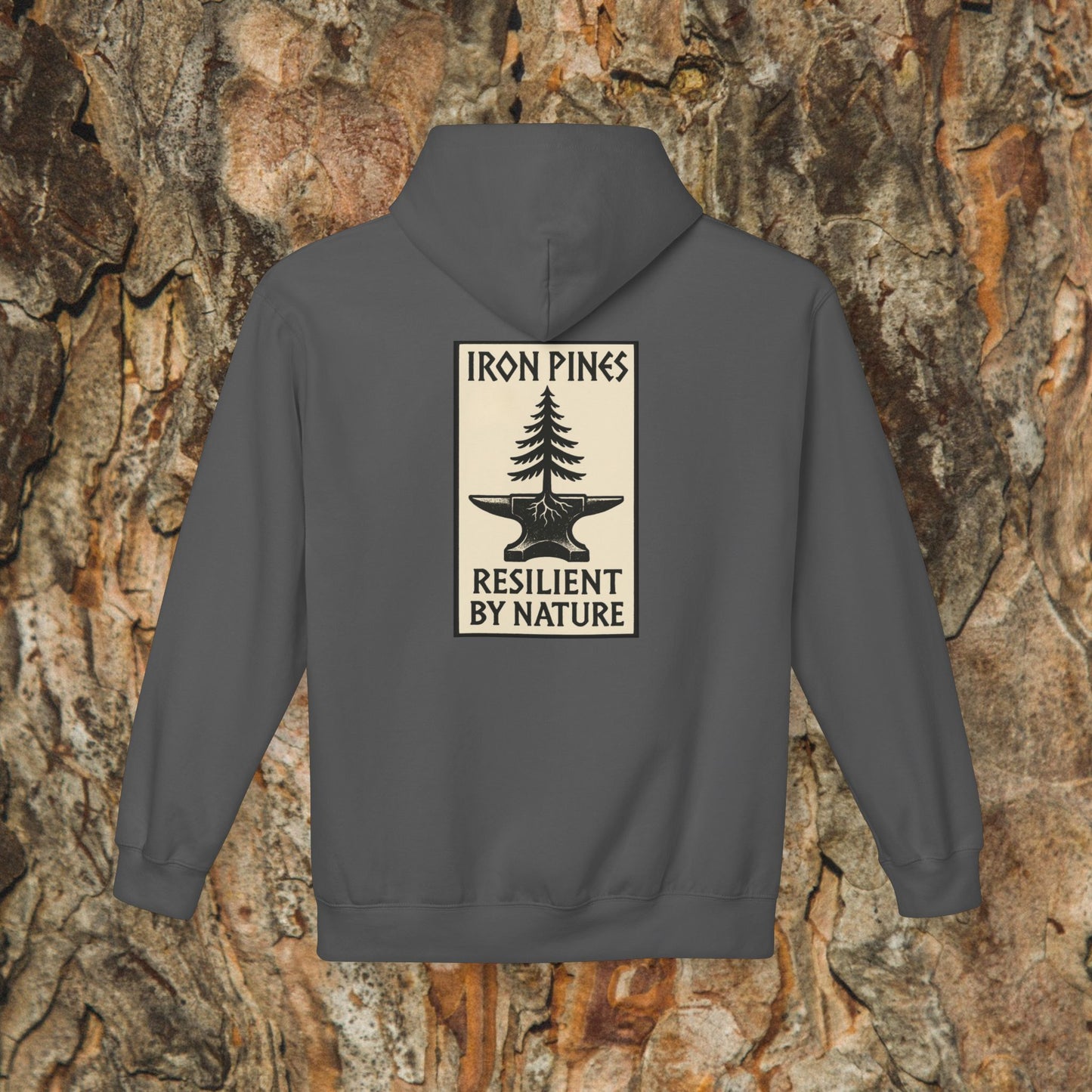 The Iron Pines Hoodie by Printify is a gray, midweight fleece with a pine-and-anvil design on tree bark. IRON PINES appears above and RESILIENT BY NATURE below—perfect sustainable outdoor apparel.
