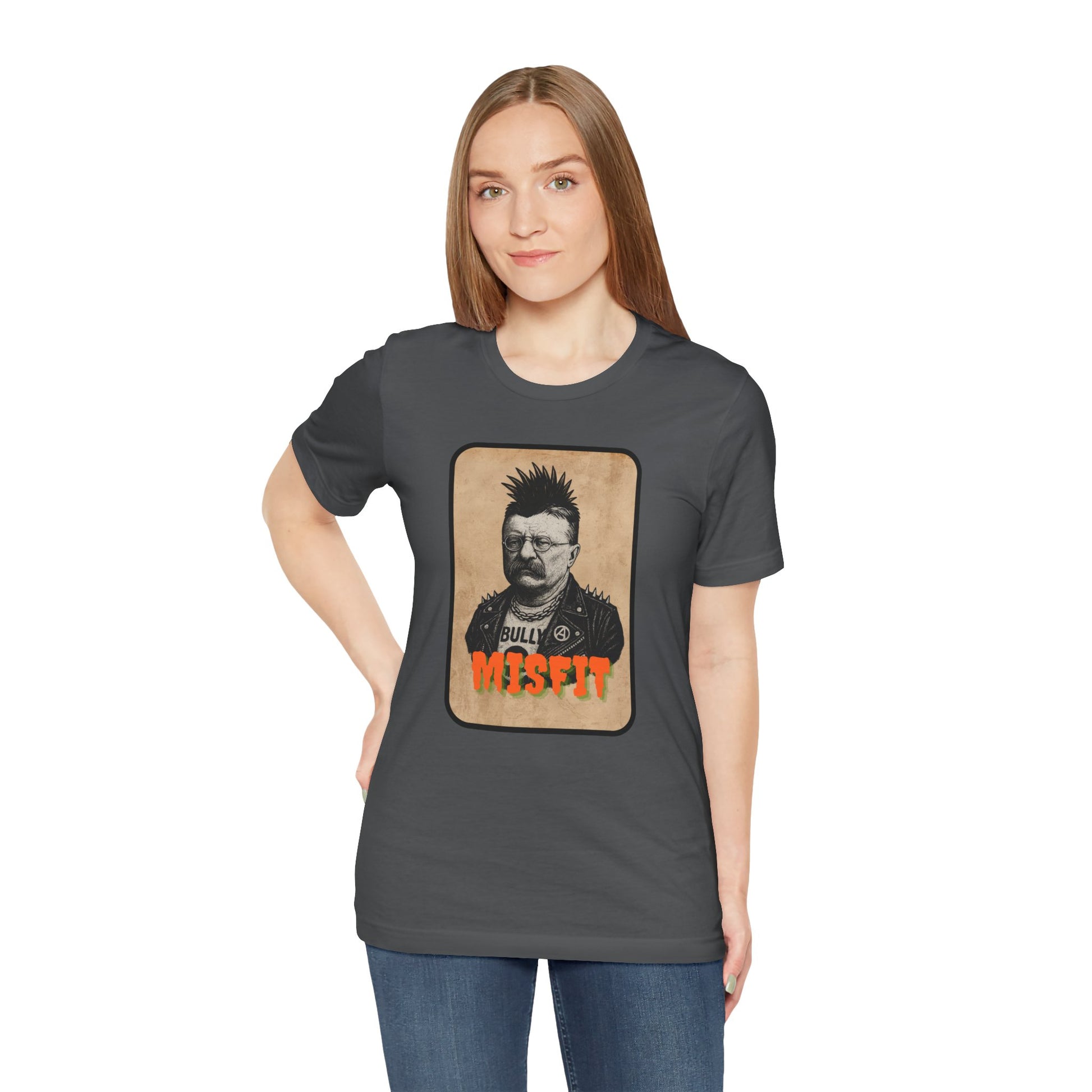 A woman with straight brown hair confidently wears the Iron Pines Teddy Roosevelt Punk T-Shirt, a dark gray misfit history tee featuring a vintage-style spiked-hair graphic—a bold choice for rebels, patriots, and wild hearts.