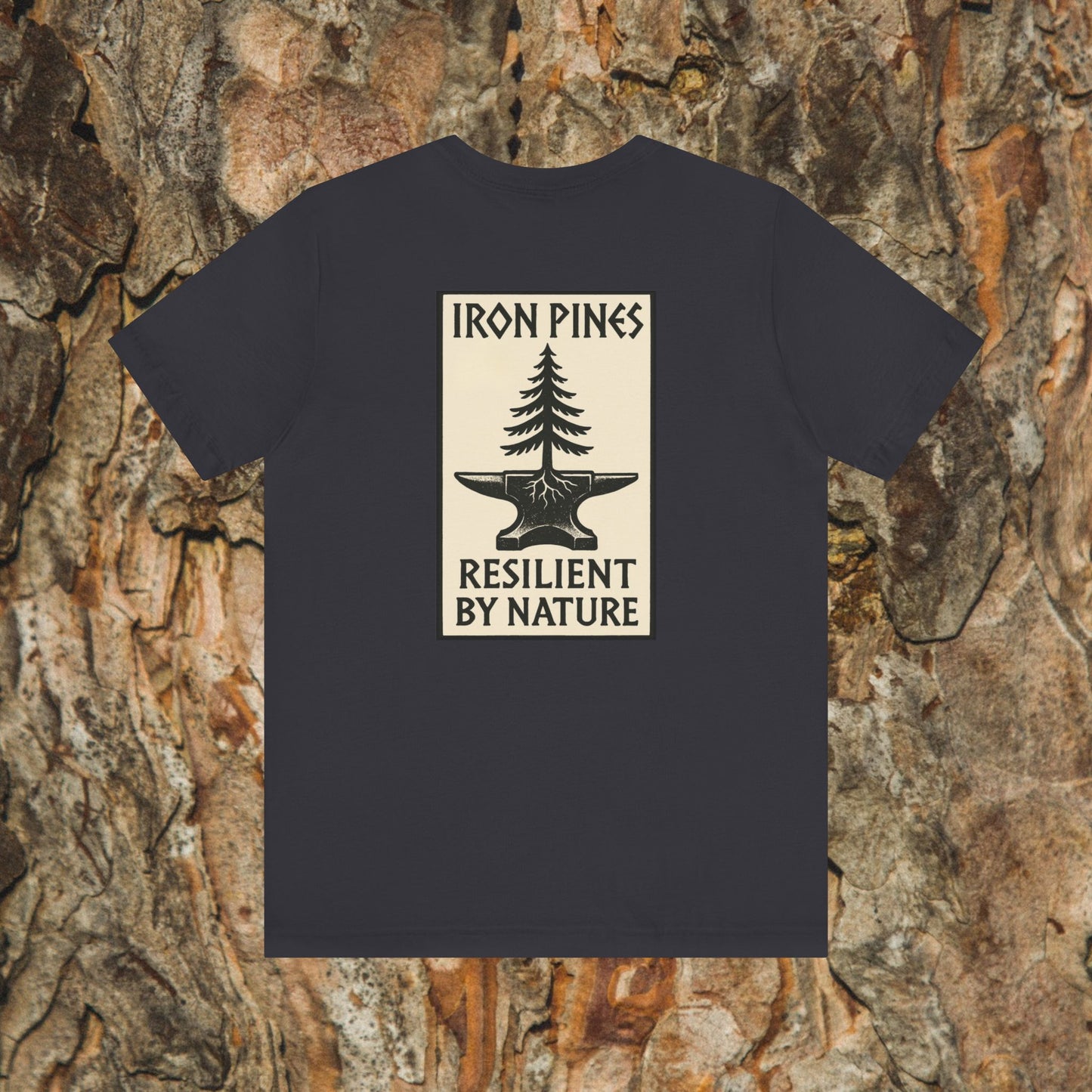 The Iron Pines Crest Tee by Printify is a black Airlume cotton shirt featuring a pine tree growing from an anvil on the back, with IRON PINES above and RESILIENT BY NATURE below. Tree bark forms the background.
