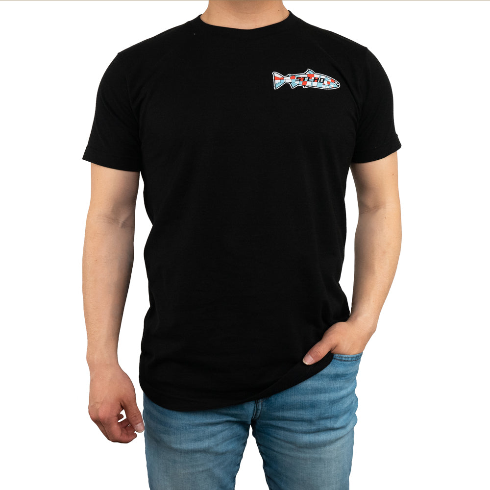 A person wears the STLHD Mens Saint Sasquatch Black T-Shirt by STLHD GEAR, featuring a small, colorful fish graphic and STLHD on the left chest, paired with blue jeans. The comfort weave offers breathable, all-day ease against a plain white background.