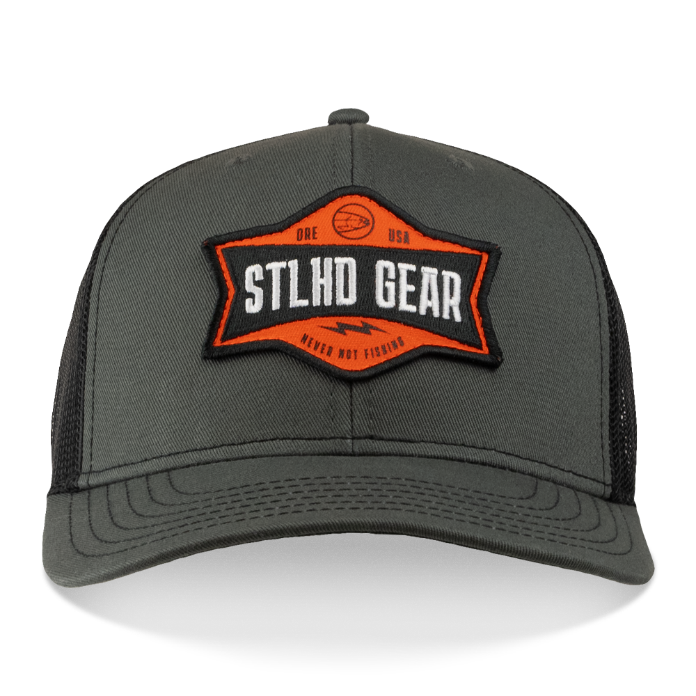 The STLHD GEAR Never Not Fishing Trucker Hat features a gray mesh back, adjustable snapback, and an orange-black patch with “STLHD GEAR” and “NEVER NOT FISHING” plus fish and basketball graphics—a perfect trucker hat for fishing.