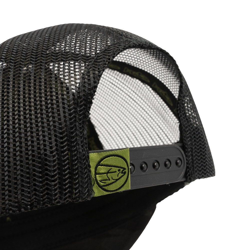 Close-up of the STLHD GEAR Black Ops Multicam Snapback Trucker Hat, showing black mesh, an adjustable snapback strap, and a green tag with a minimalist fish logo on the back.