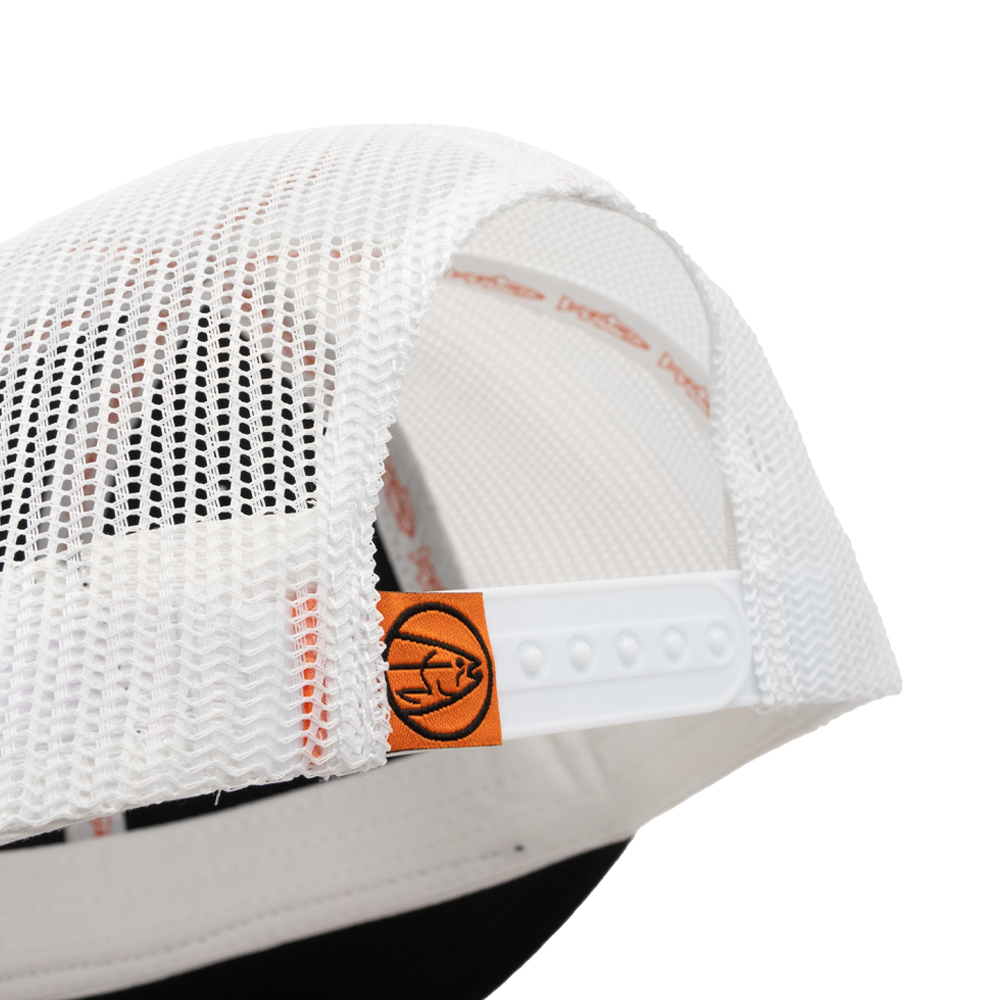 Close-up of the STLHD Standard White & Black Trucker Hat by STLHD GEAR, showing its white mesh back, orange fish logo tag, adjustable snapback strap, and part of the black brim against a white background.