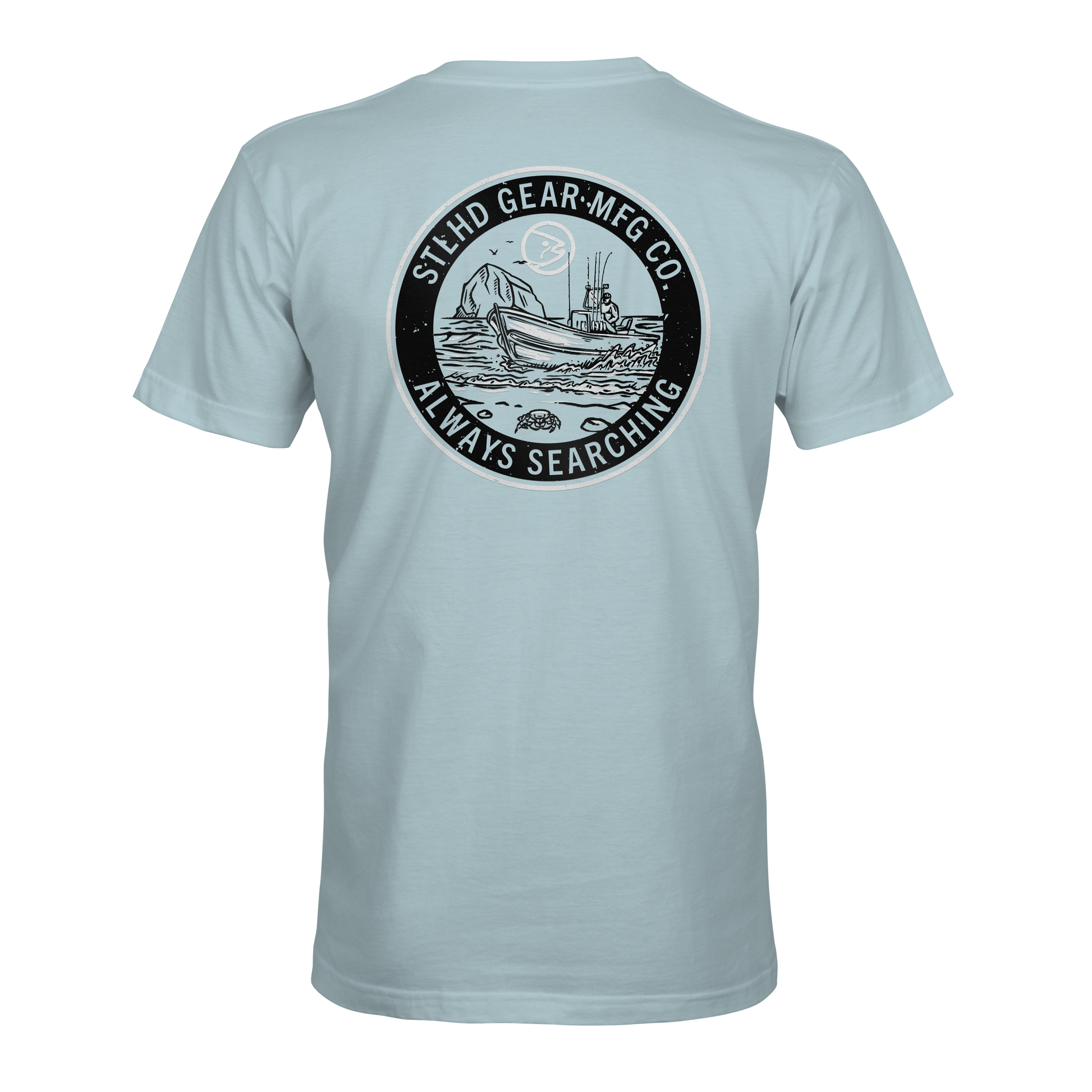 The STLHD Coastie T-Shirt by STLHD GEAR features a light blue design with a circular ship-at-sea graphic and STLHD GEAR MFG CO. ALWAYS SEARCHING text—ideal breathable comfort for any outdoorsmans collection.