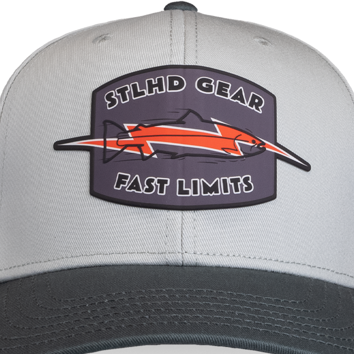 A close-up of the STLHD GEAR Fast Limits Hat, an adjustable gray snapback with a breathable design and a patch featuring an orange and black fish with the text STLHD GEAR FAST LIMITS.