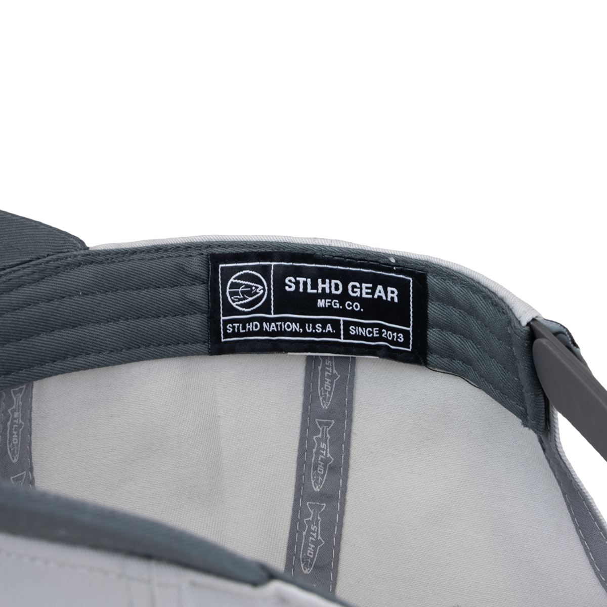 Close-up of the STLHD Fast Limits Hat interior, featuring a black and white STLHD GEAR label with a fish logo and text: “STLHD GEAR MFG. CO. STLHD NATION, U.S.A. SINCE 2013.”.