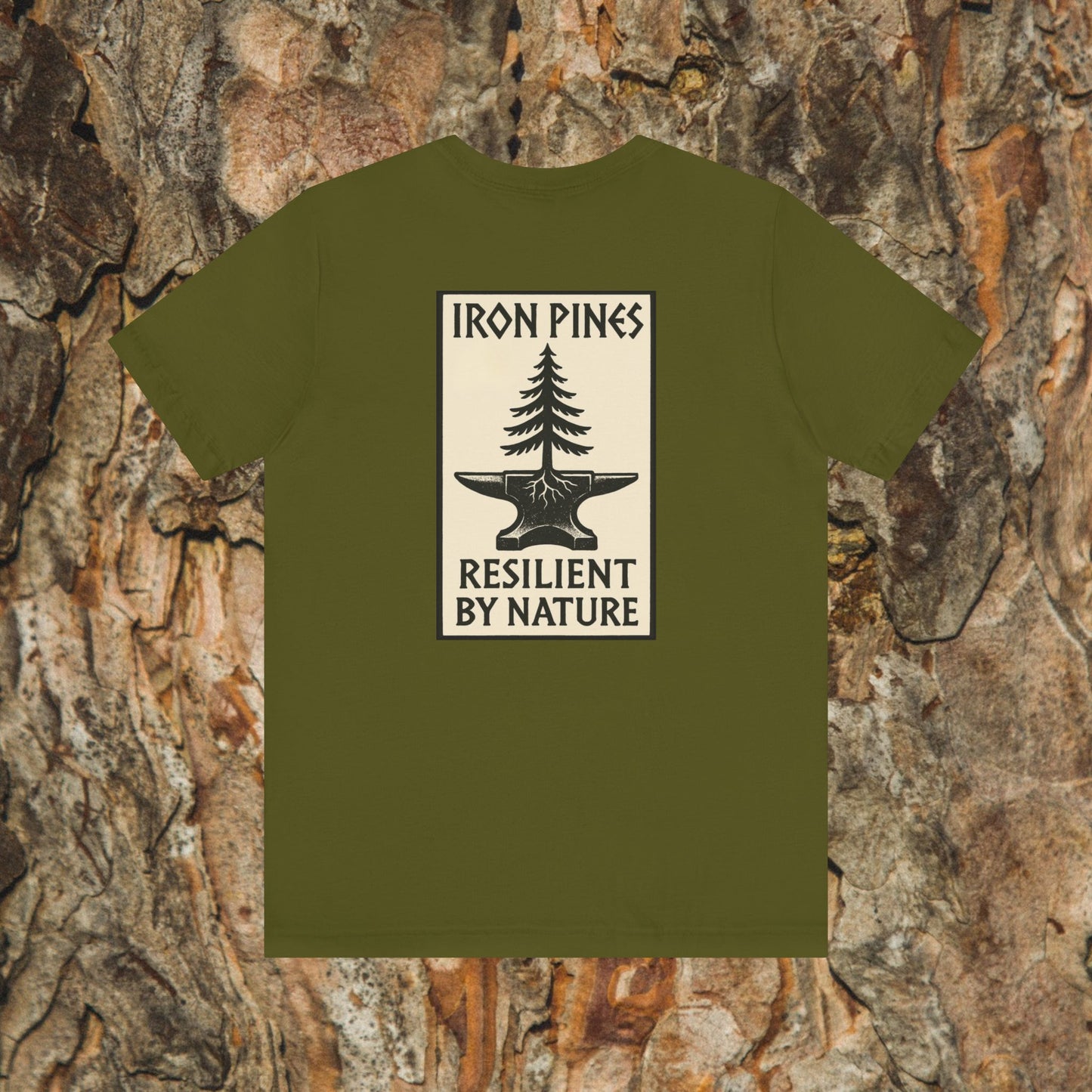The Iron Pines Crest Tee by Printify is a sustainable olive green Airlume cotton shirt with a pine tree and anvil graphic, IRON PINES above, RESILIENT BY NATURE below, and tree bark backdrop.