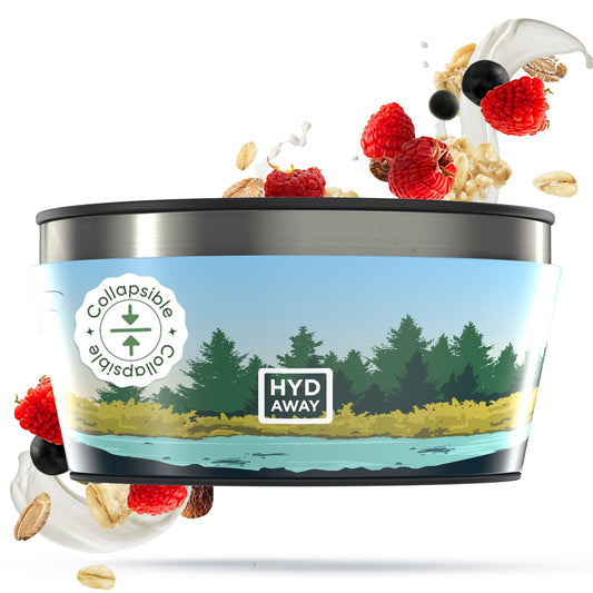 The HYDAWAY 1‑Quart Collapsible Insulated Bowl from the HYDAWAY Official Store sits before an illustrated forest and lake, with oats, berries, and yogurt splashes artfully arranged around the BPA-free silicone bowl.