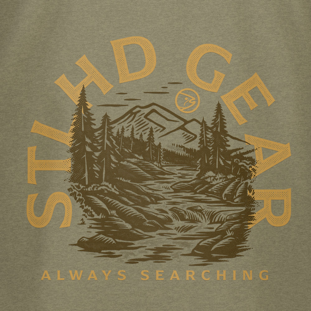 Featuring a forest, mountains, and river illustration with bold STLHD GEAR and “ALWAYS SEARCHING” below, the STLHD Mountain View T-Shirt is perfect outdoor apparel for adventure seekers who value comfort.