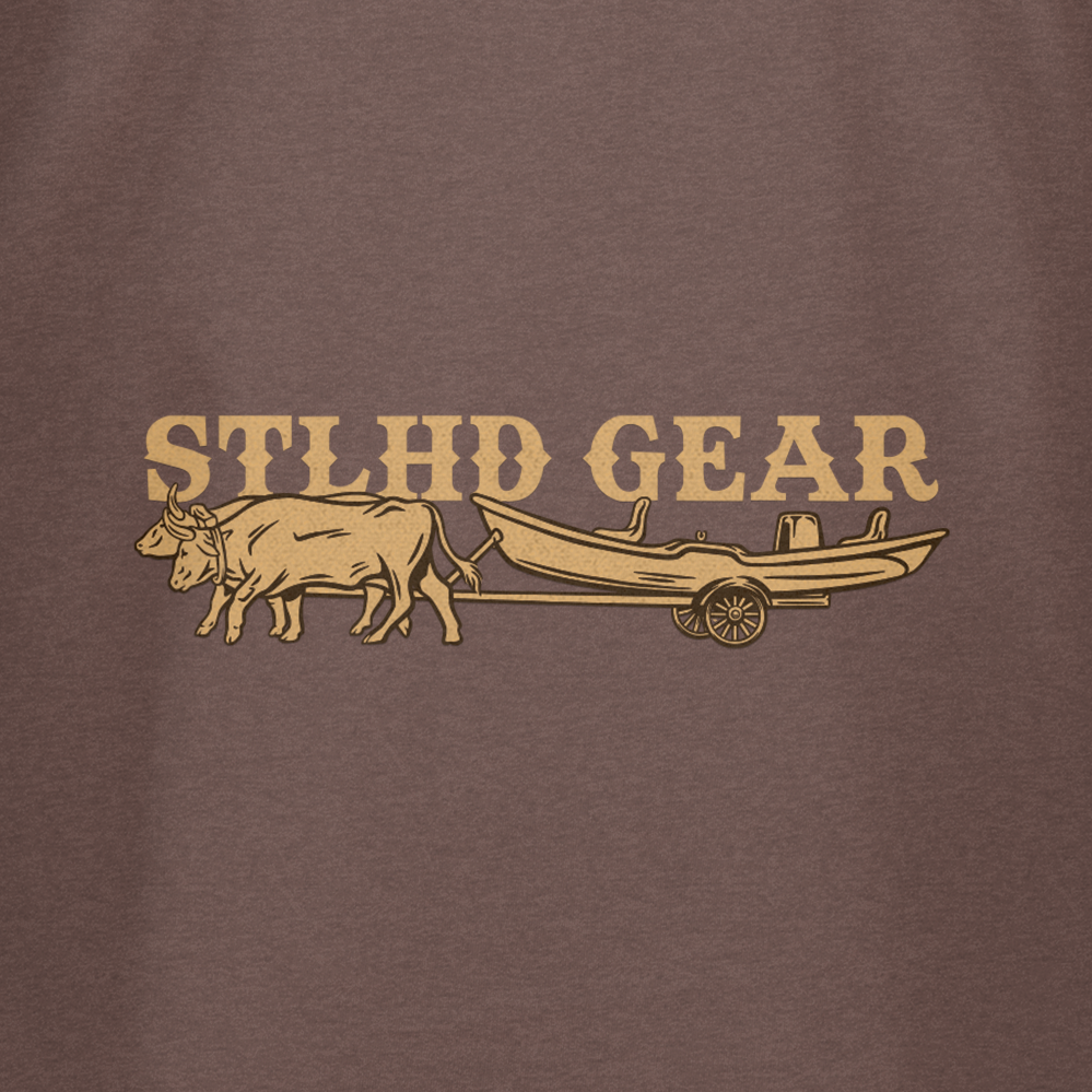 The STLHD Oregon Trail T-Shirt by STLHD GEAR features an ox pulling a wooden cart with the brand name above, set on a brown background—ideal for fans of Oregon Trail tees and those seeking breathable comfort.