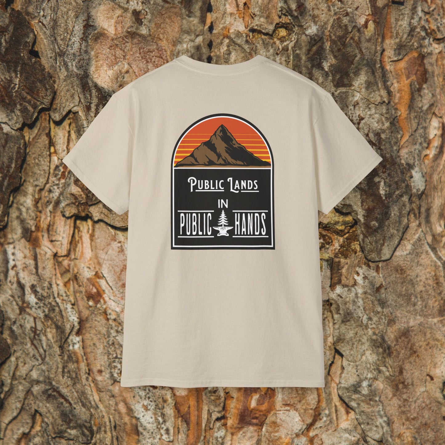 The Iron Pines Public Lands in Public Hands Tee is a beige hiking t-shirt made from ethically sourced cotton, featuring a back graphic of a sunset mountain, “Public Lands in Public Hands” text, and a textured bark background.