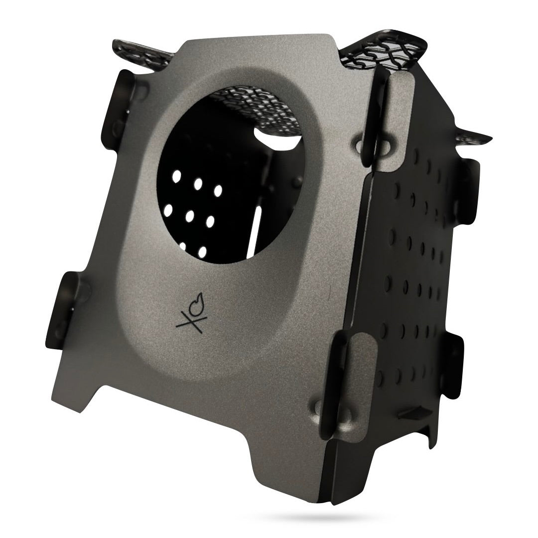 The Überleben Stöker Flatpack Stove by Überleben is a compact, foldable metal wood-burning stove with ventilation holes and a side circular opening—ideal for camp stove enthusiasts. Pictured against a white background.