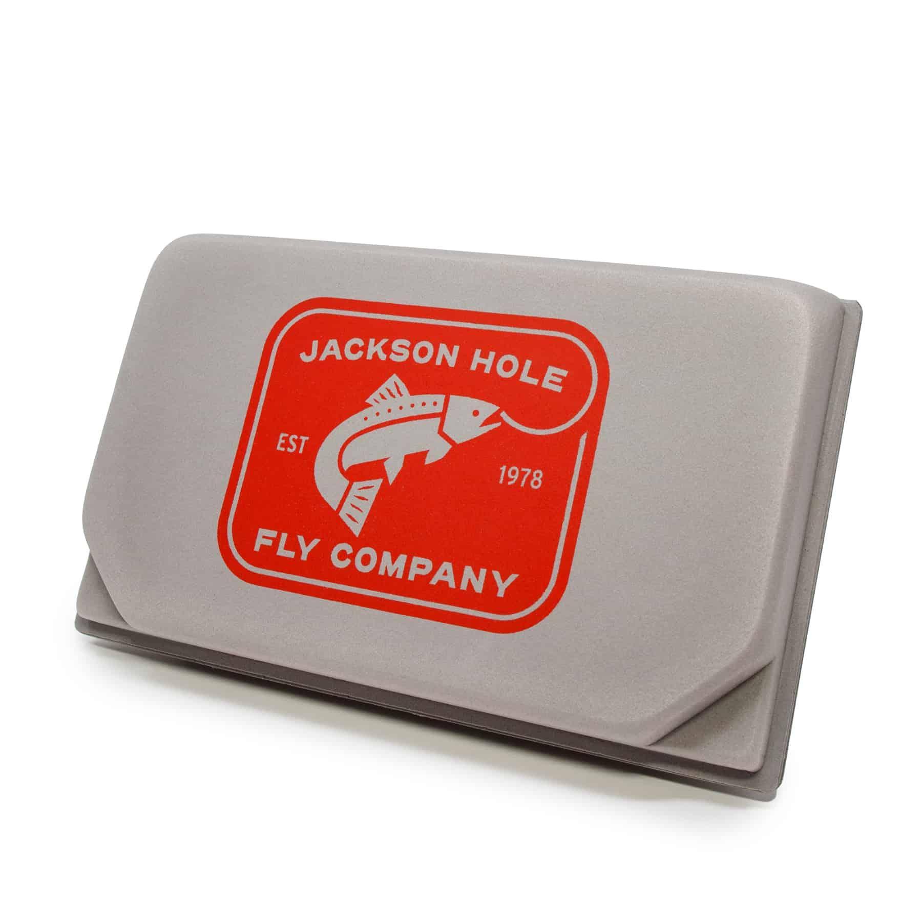 The JHFLYCO Loaded Foam Fly Box - Euro Nymph Assortment by Jackson Hole Fly Company is a gray tungsten jig box with a red Jackson Hole Fly Company EST 1978 logo and a fish illustration.