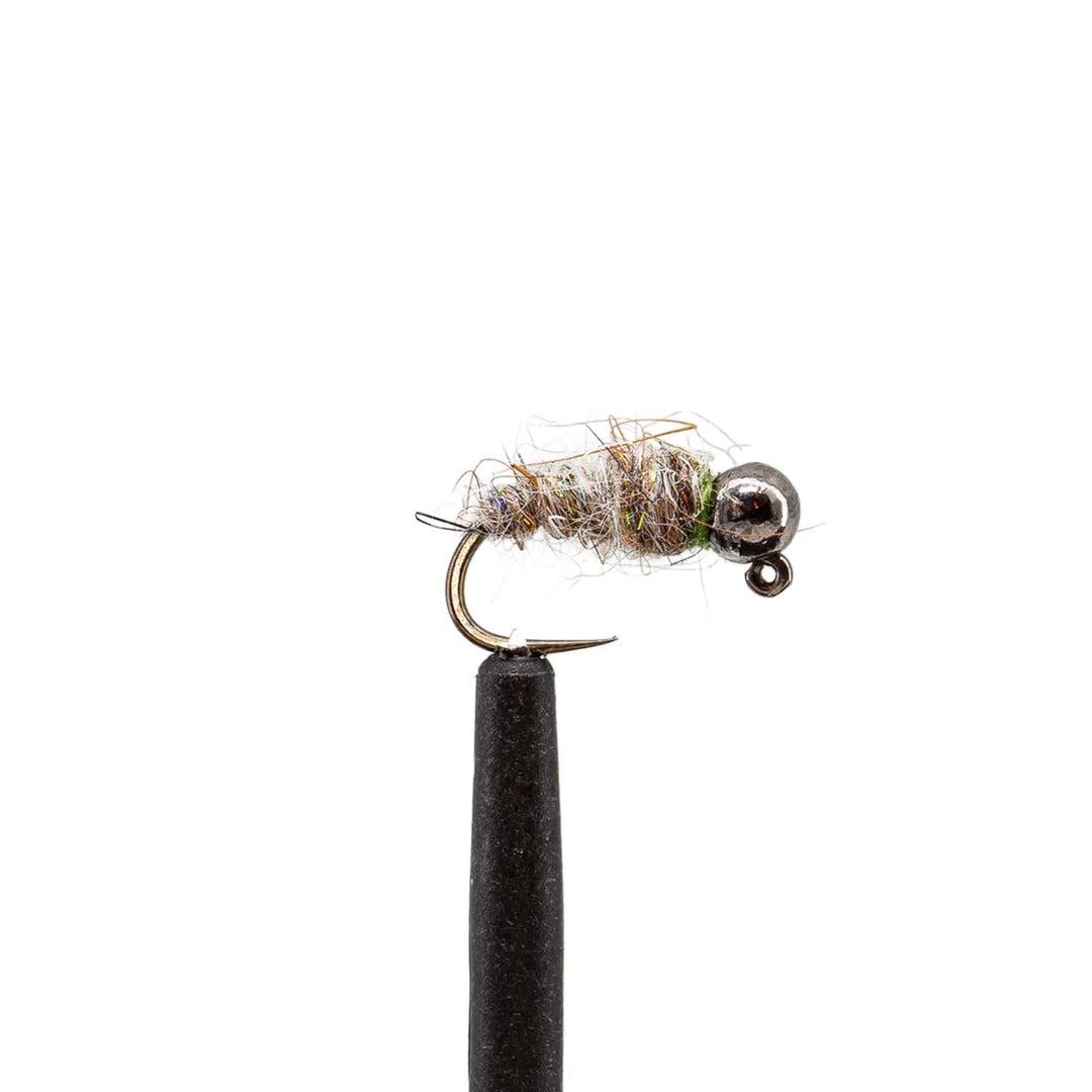 A close-up of a tungsten jig from the JHFLYCO Loaded Foam Fly Box - Euro Nymph Assortment by Jackson Hole Fly Company, showing its metallic bead head, fuzzy thread body, and sharp hook against a white background.