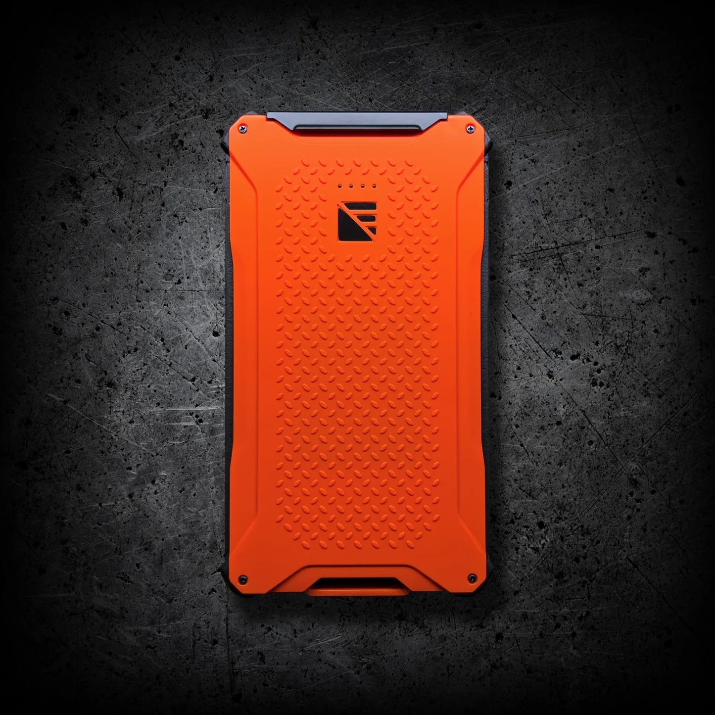 The Entropy Survival Off Grid Survival Power Bundle, featuring a rugged orange design with black corners, sits atop a dark, scratched concrete-like surface.