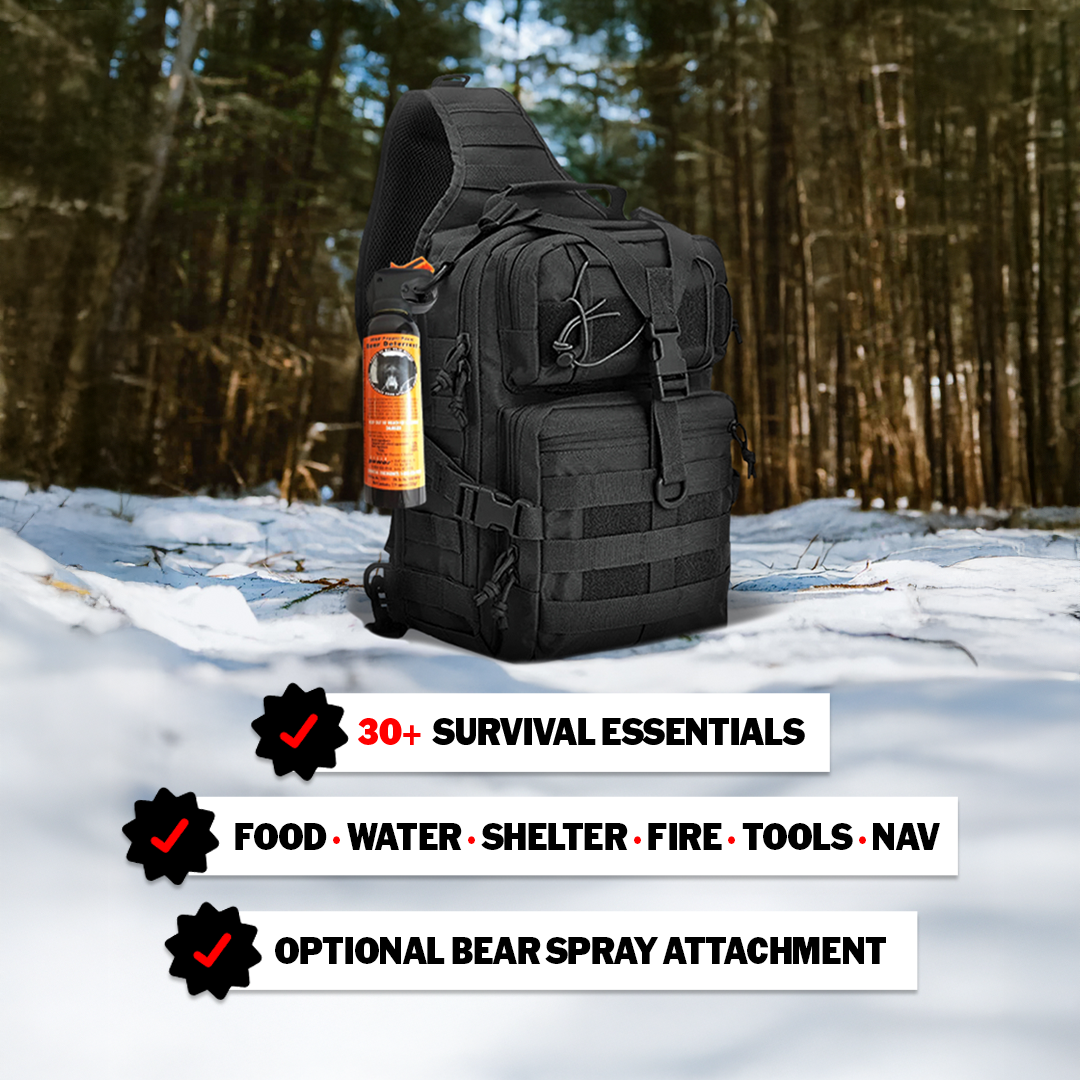 A black Entropy Survival Safe Trail “Survive-All” Go Bag with bear spray sits on snowy forest ground. Text highlights survival essentials: food, water, shelter, fire, tools, navigation, and optional emergency kit items.