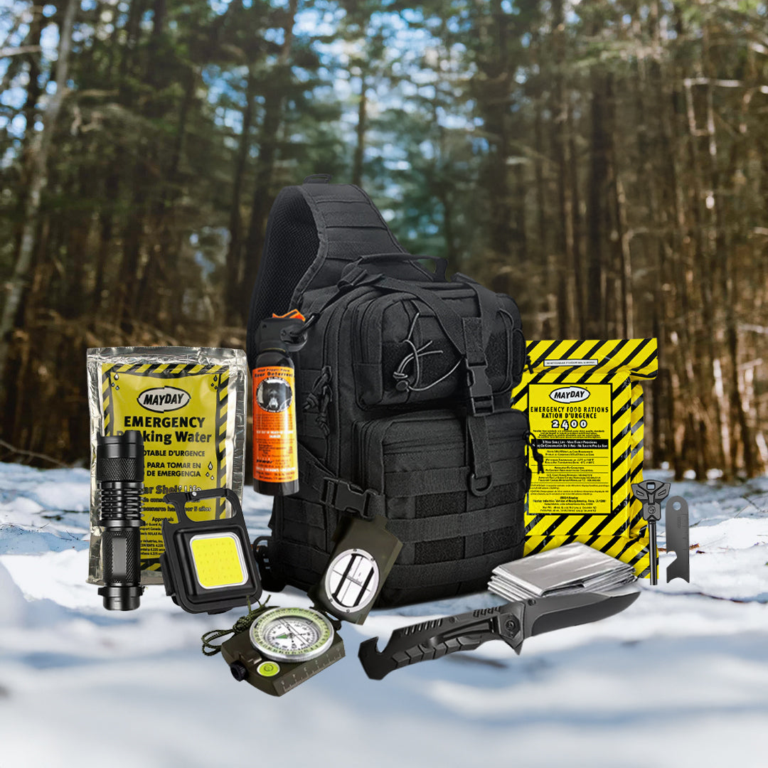 The Entropy Survival Safe Trail “Survive-All” Go Bag—a black tactical backpack—is packed with survival essentials like a flashlight, compass, multi-tool, water pouch, and emergency food rations for any challenge in the snowy forest.