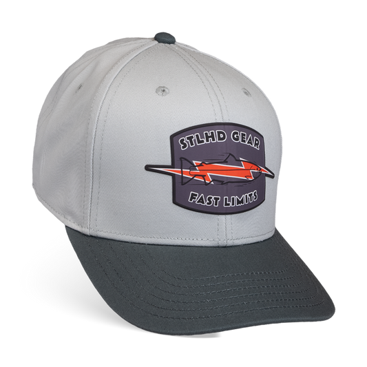 The STLHD GEAR Fast Limits Hat features a light gray crown, dark gray bill, and a patch with a stylized fish and orange bolt. This two-tone adjustable snapback offers breathable comfort for any adventure.