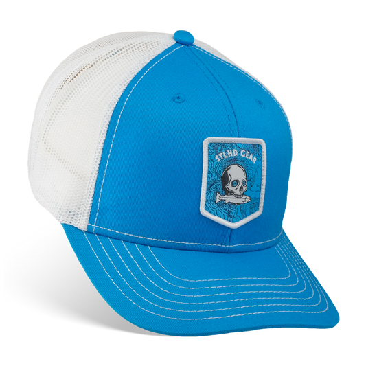 Blue and white cap with a STLHD GEAR skull and fish patch on a white background