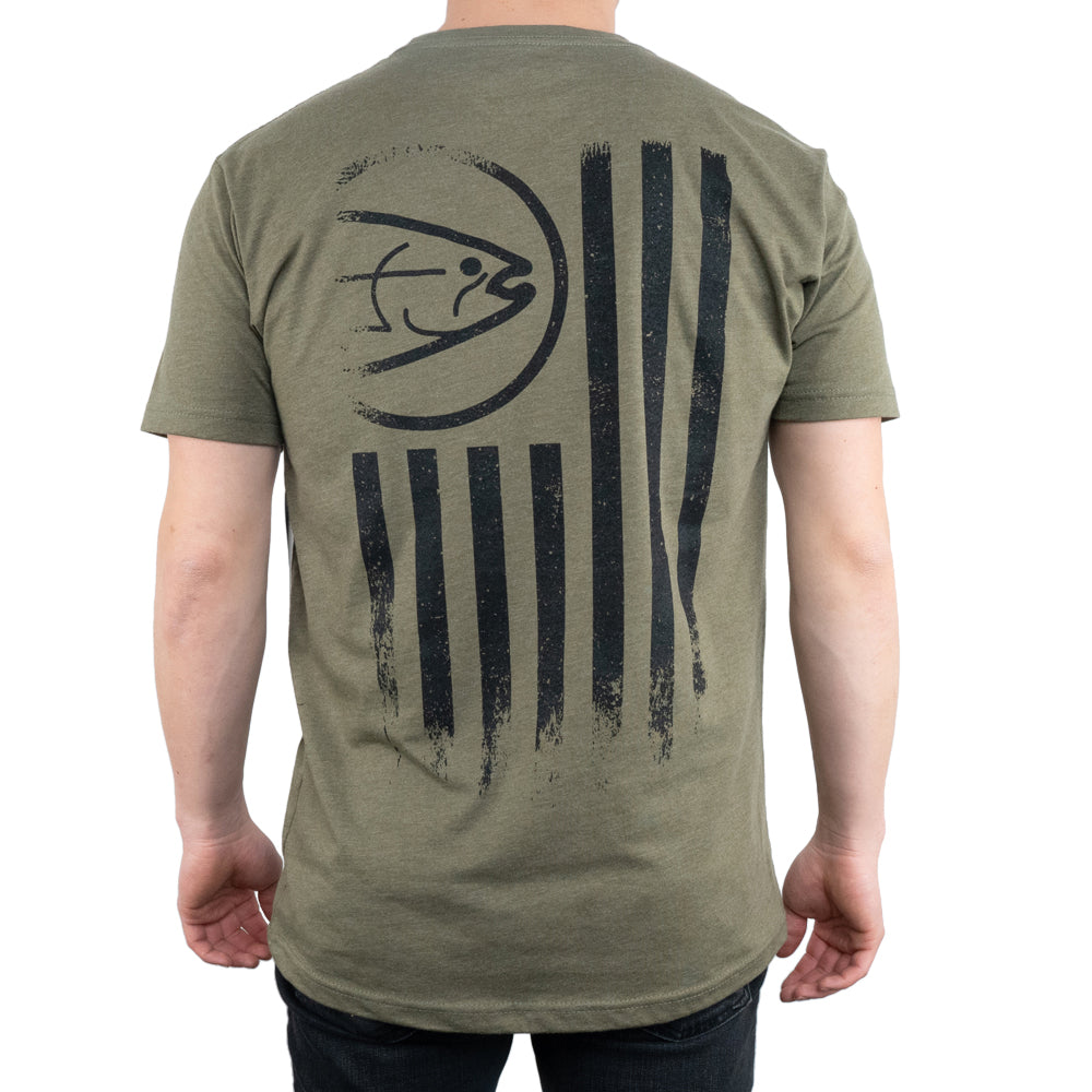 A person stands facing away, wearing the STLHD GEAR Mens United T-Shirt in Military Green, featuring Chromelite material, black vertical brushstroke stripes, and a circular STLHD Nation graphic with text on the back.
