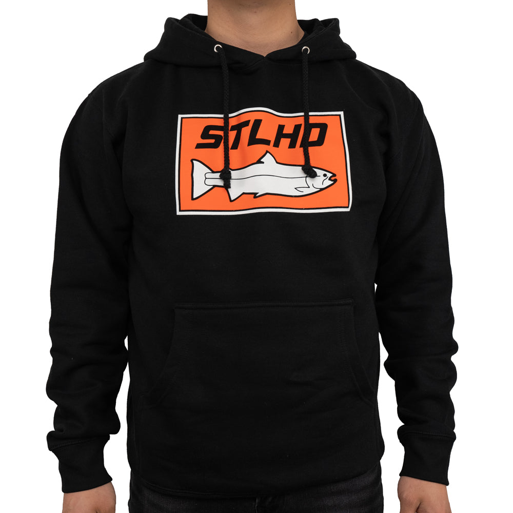 A person wears the STLHD Mens Standard Logo Black Premium Hoodie by STLHD GEAR, featuring an orange rectangular logo with a fish and STLHD above it—a great fishing hoodie for enthusiasts with a convenient front pocket.