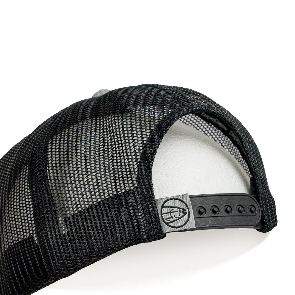 A close-up of the STLHD GEAR Chrome Edition Heather Grey/Black Trucker Snapback Hat shows black mesh, an adjustable snapback strap, and a small logo tag on the back.