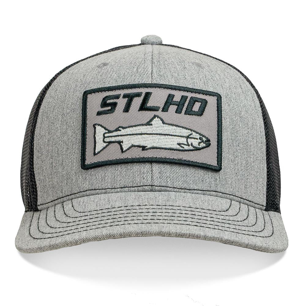 The STLHD GEAR Chrome Edition Heather Grey/Black Trucker Snapback Hat features a rectangular front patch with STLHD text above an outlined fish and includes an adjustable snapback for a perfect fit.
