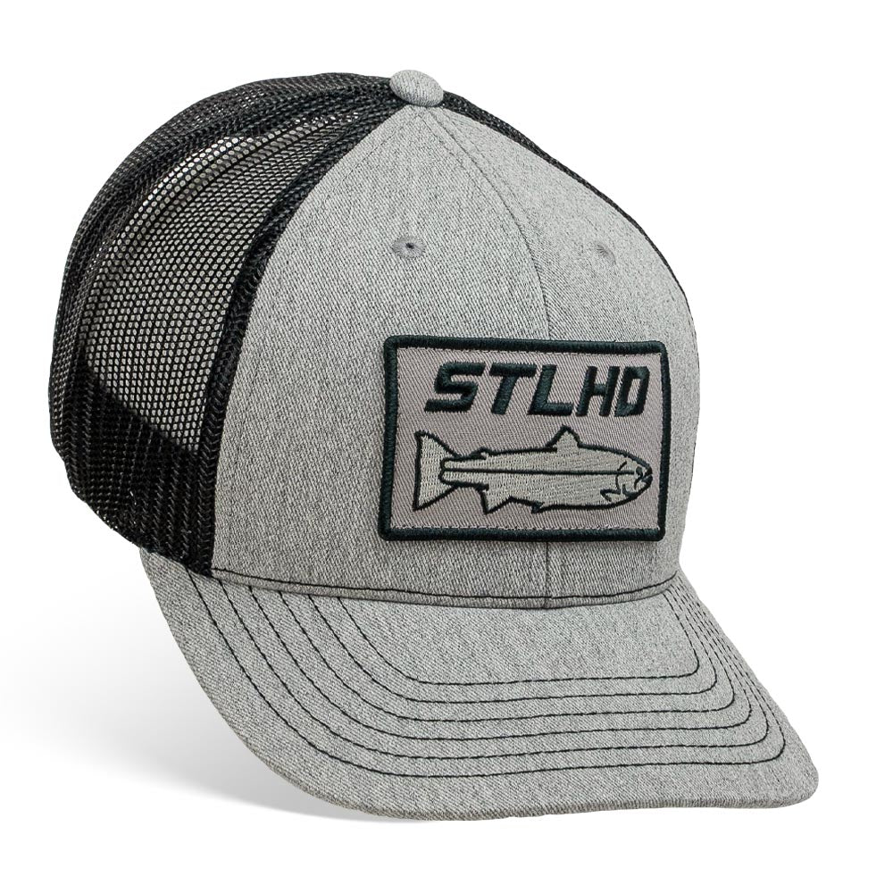 The STLHD GEAR Chrome Edition Heather Grey/Black Trucker Snapback Hat features a black mesh back, STLHD fish outline patch, and an adjustable closure for the perfect fit.