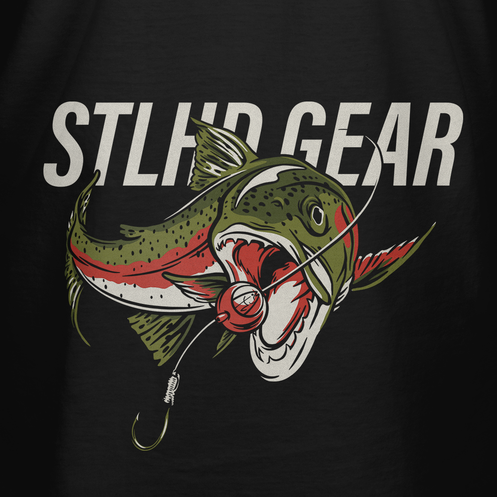 A green, red, and white fish jumps with an open mouth toward a lure under bold STLHD GEAR text on the STLHD Men’s Chomper T-Shirt, made from breathable CHROMELITE material for ultimate comfort.