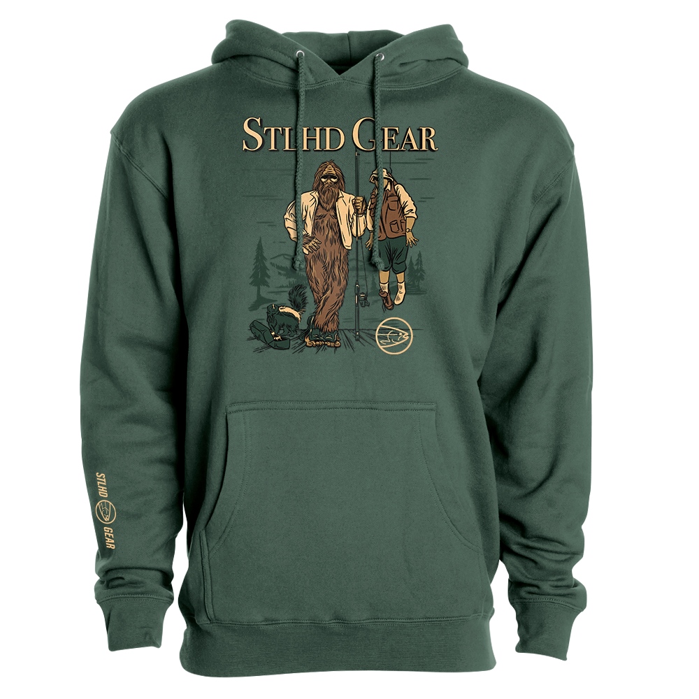 Green hoodie with graphic design of Bigfoot holding up a man with a fishing rod, with STLHD GEAR TEXT across the top', on a white background.