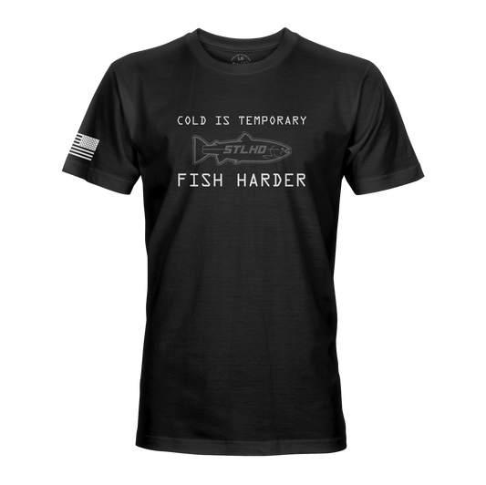 The STLHD Fish Harder T-shirt from STLHD GEAR features “COLD IS TEMPORARY” over a fish outline, “FISH HARDER” below, and an American flag on the right sleeve—perfect for dedicated anglers.