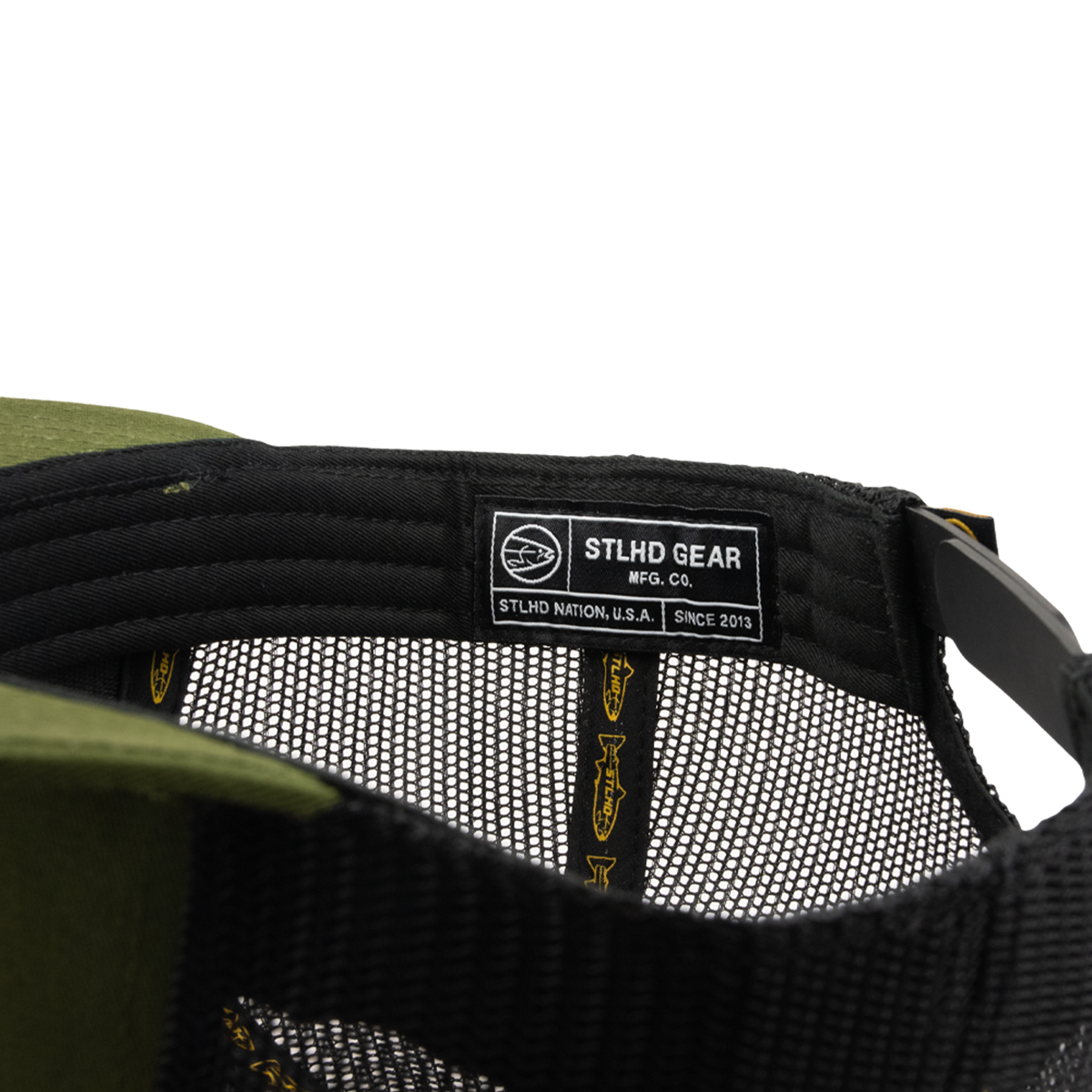 Close-up of the inside of the STLHD Race Ya Flat Bill Trucker Hat by STLHD GEAR, featuring a label reading STLHD GEAR MFG. CO. STLHD Nation, U.S.A. SINCE 2013 sewn onto the inner band and an adjustable snapback for a perfect fit.
