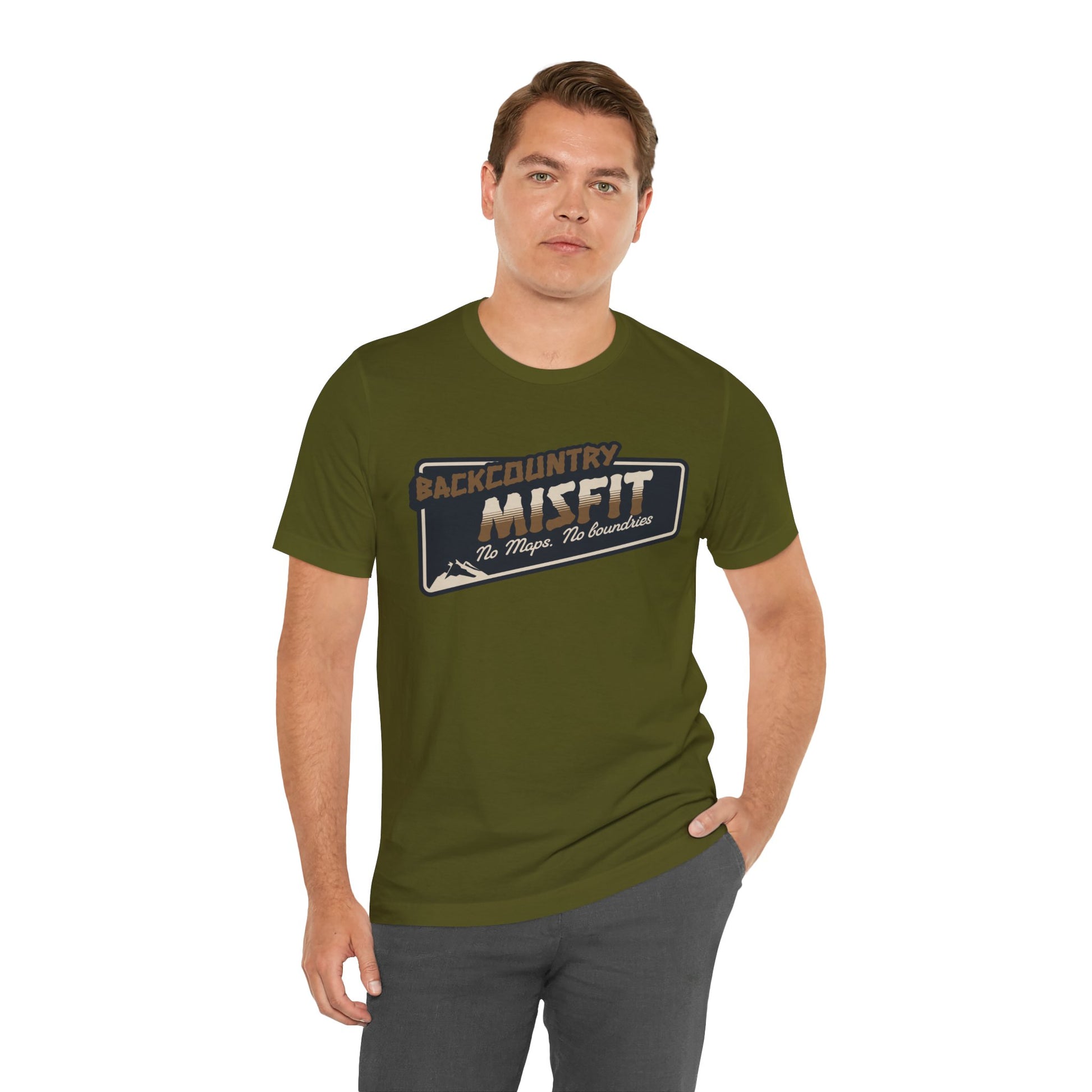 A man stands with one hand in his pocket, wearing the Printify Backcountry Misfit T-Shirt—a rugged hiking tee for trail rebels and off-grid wanderers—featuring Backcountry Misfit: The Maps. The Mountains on the front. Perfect for any adventure.