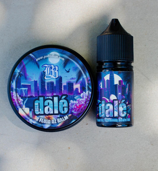 A round tin of DALÉ Beard Balm and a small bottle of DALÉ Beard Oil by Bedlam Beard Company, both with blue and purple labels featuring a city skyline, palm trees, and dalé, rest on a light surface.