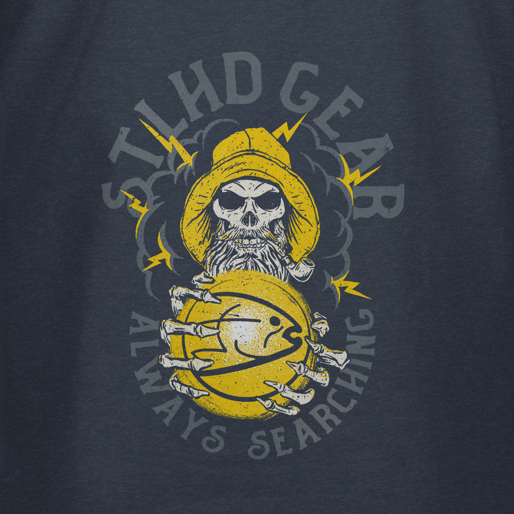 Navy blue t-shirt with yellow graphic design on the back featuring a skull in a fisherman's hat and STLHD GEAR ALWAYS SEARCHING text on a dark background.