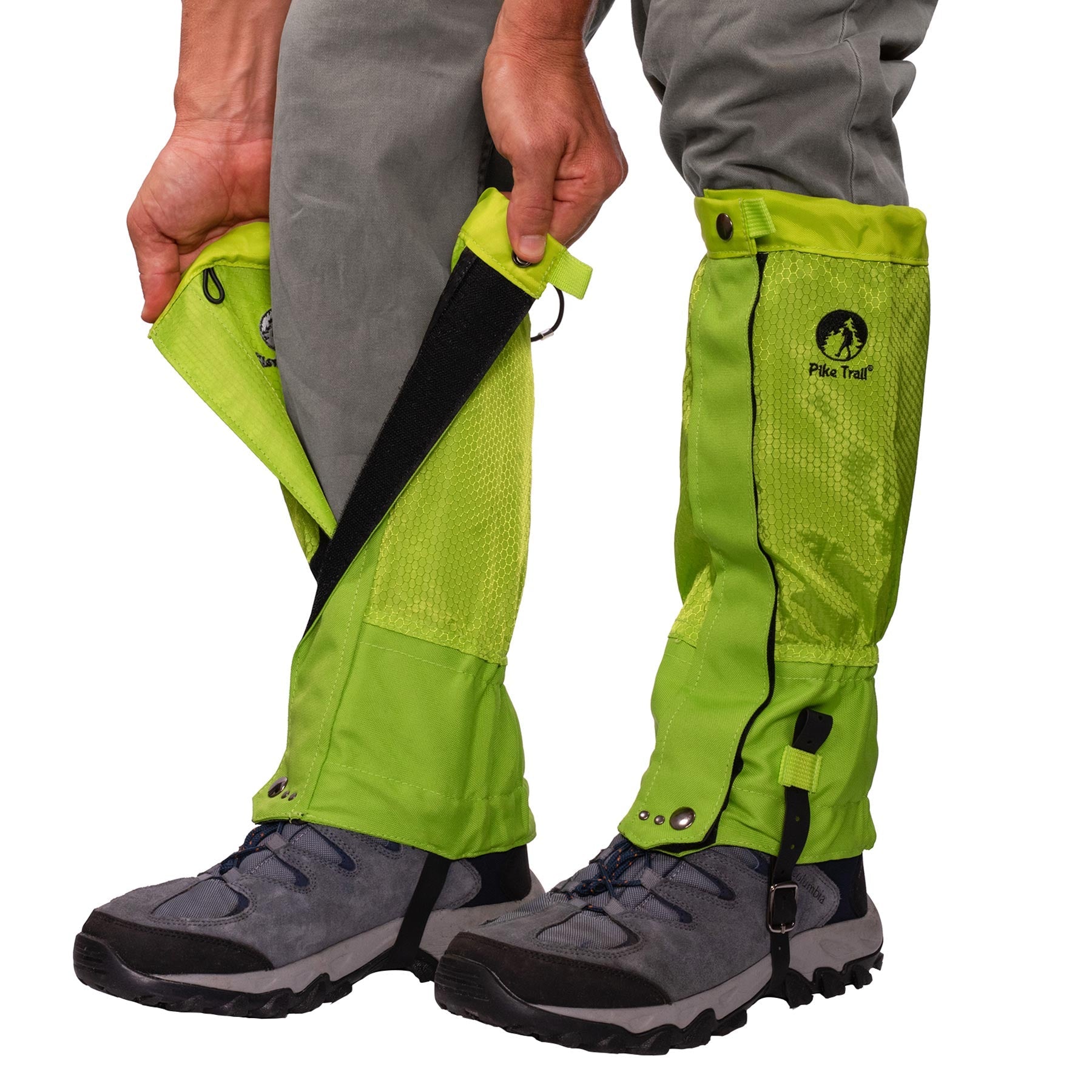 A person fastens Pike Trail All-Season Waterproof Leg Gaiters with black Velcro closures over gray pants and hiking boots for outdoor protection on the trail, the hunt, and everything in between.