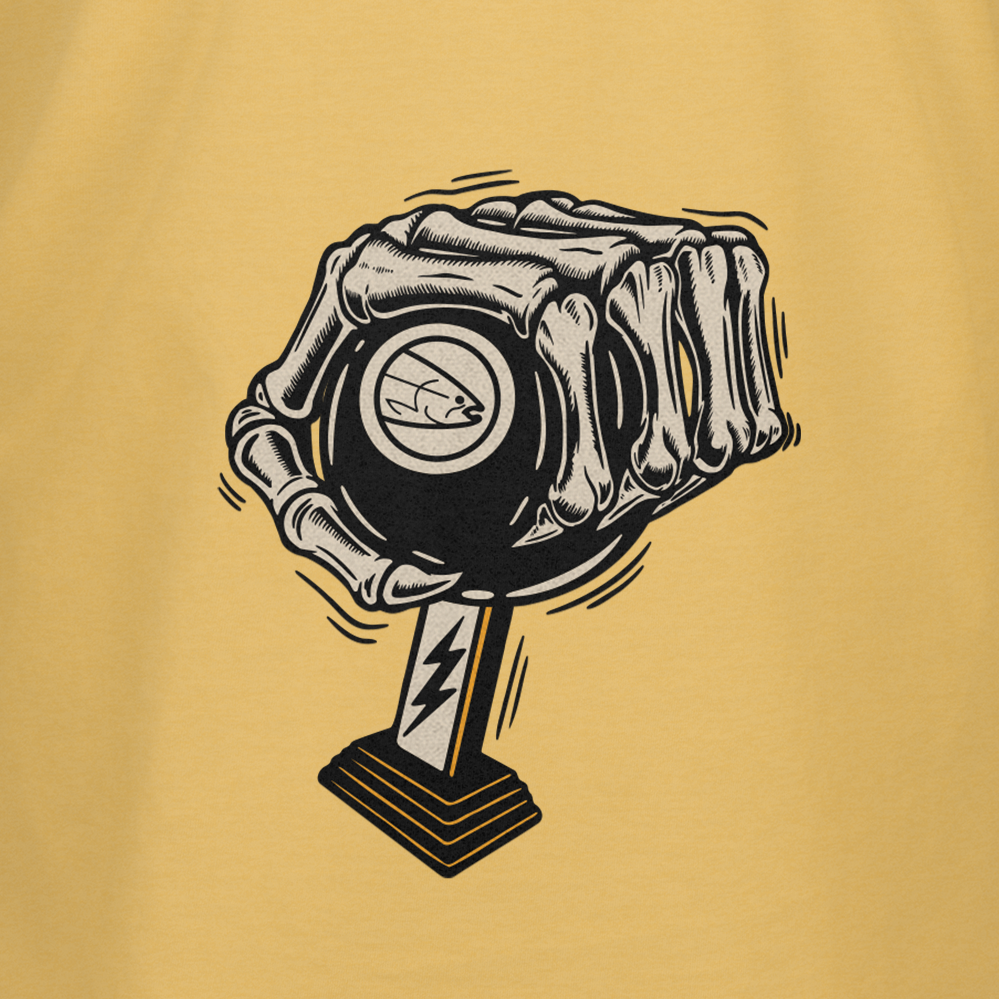 A stylized skeletal hand grips a black magic 8-ball with a fish symbol, set on a stand with a lightning bolt, against a tan background—featured on the STLHD Race Ya T-Shirt by STLHD GEAR for breathable comfort.