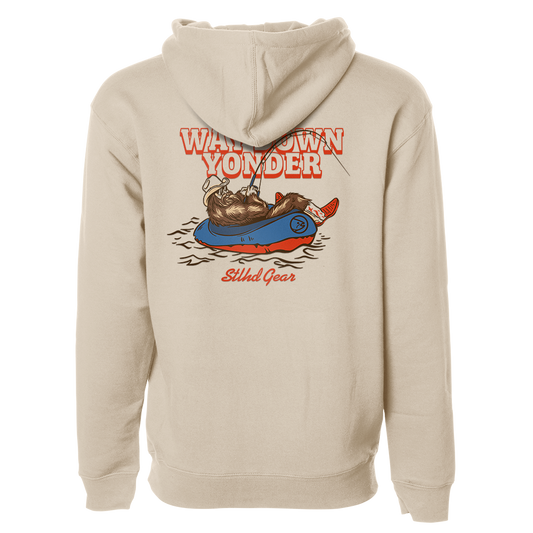 Beige hoodie with a graphic design on the back featuring  Way down yonder STLHD GEAR text and an image of bigfoot with cowboy boots and hat fishing from a raft in a body of water.