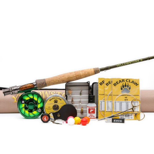 The Fall Creek Rod Combo Kit – 70 4WT by Jackson Hole Fly Company includes a lightweight fly rod, reel, line, hooks, flies, bobbers, line clipper, floatant, and packaging—an ideal trout fishing set in front of a tan rod case.