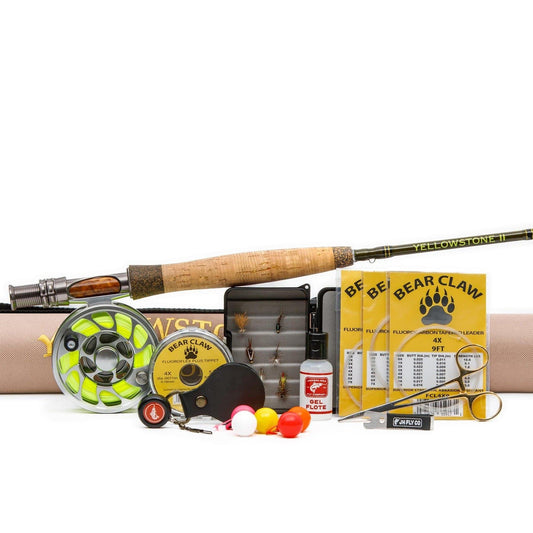 The Jackson Hole Fly Company Flat Creek Rod Combo Kit – 90 5WT includes a fly rod with tan grip, reel, flies, fishing lines, bobbers, line clippers, and a fly box—all organized for beginner anglers and ready for the river.
