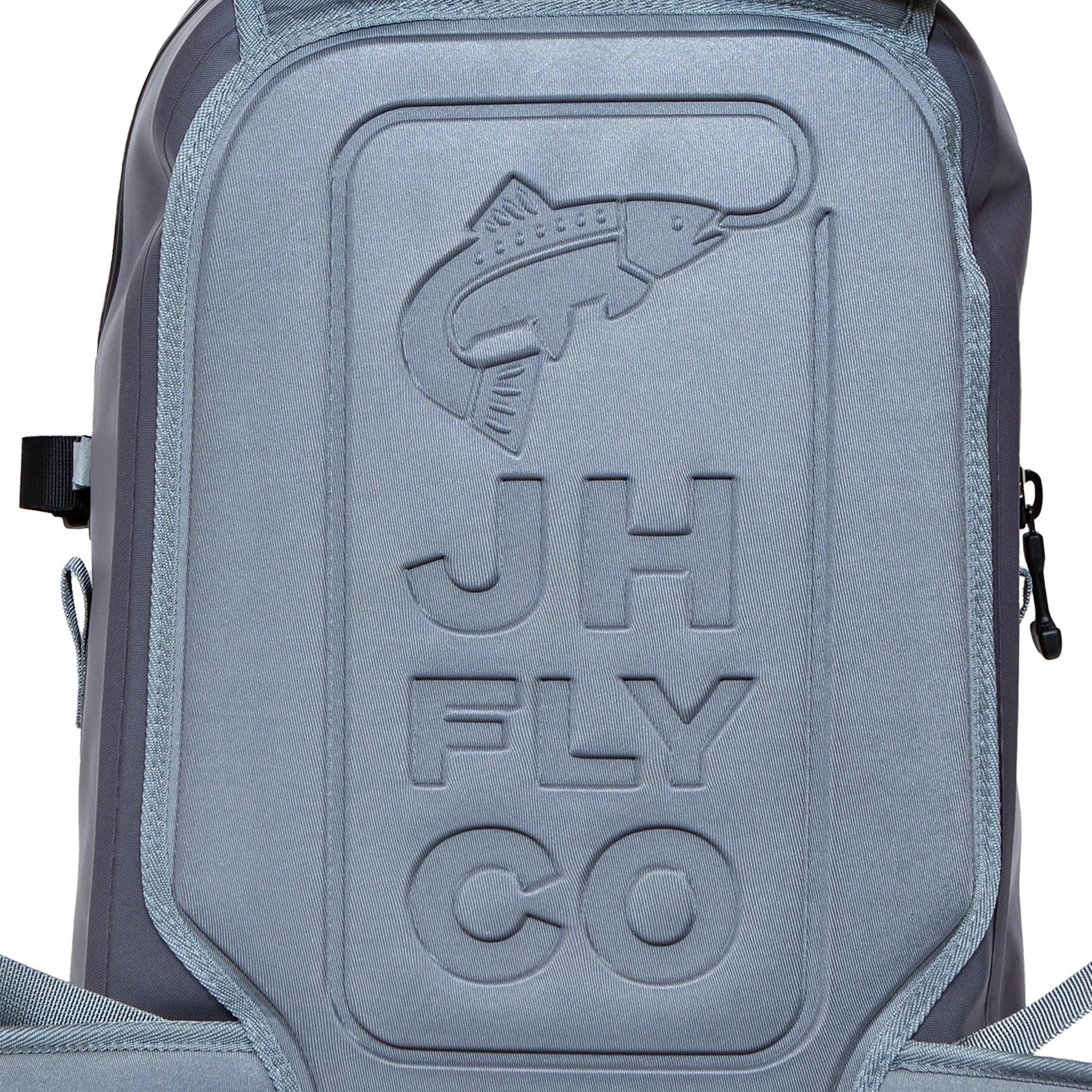 Close-up of the JHFLYCO 27L Waterproof Backpack by Jackson Hole Fly Company, made from gray 500D PVC with an embossed fish design, JH FLY CO on the front, and a rugged TIZIP zipper on the right side. Ready for the Wild.