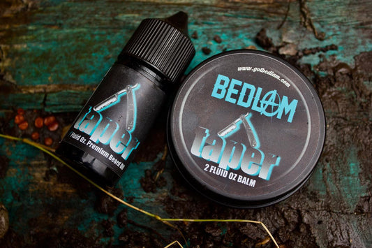 Two containers of Bedlam Beard Company TAPER Beard Oil & Balm, cedar leather scent, rest on a rustic wood surface. A small bottle and a round tin show blue and white logos featuring a straight razor graphic.